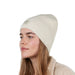Female model in profile wearing the Barts Darty Beanie in Cream. Demonstrating how the higher fit of this soft, ribbed knit beanie looks.