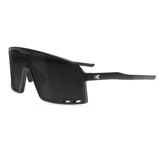 Black sunglasses with a Knockaround brand logo on a white background. Now available from ICEGRIPPER, the Knockaround Campeone Black on Black combines advanced performance technology with rugged outdoor style — ideal for trail runners, winter hikers, mountain trekkers, and polar explorers who demand comfort and clarity in challenging light conditions. Buy now at ICEGRIPPER.