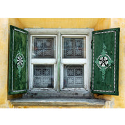 Antique shuttered window with green shutters on a yellow walltique. Typical of what you will find in the Engadine, Switzerland