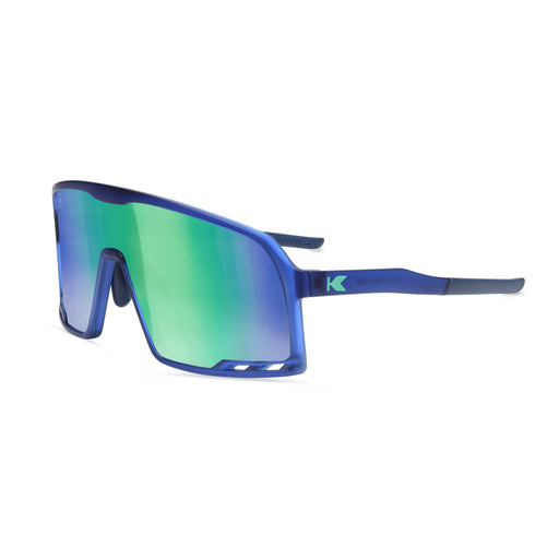 Blue sunglasses with blue-green reflective lenses on a white background. Now available from ICEGRIPPER, the Knockaround Campeone Navy Mint combines advanced performance technology with rugged outdoor style — ideal for trail runners, winter hikers, mountain trekkers, and polar explorers who demand comfort and clarity in challenging light conditions. Buy now at ICEGRIPPER.