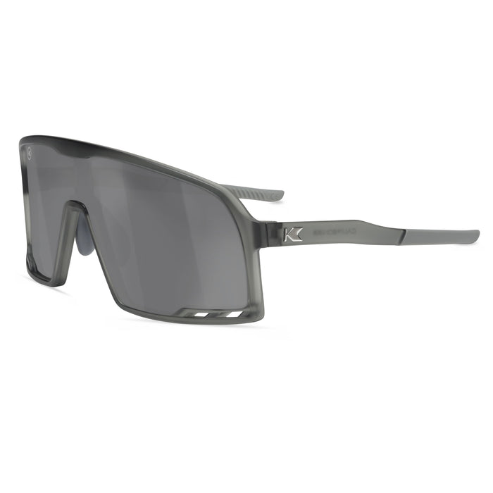 Sunglasses with a gray frame and dark lenses on a white background. Now available from ICEGRIPPER, the Knockaround Campeone Robotron 5000 combines advanced performance technology with rugged outdoor style — ideal for trail runners, winter hikers, mountain trekkers, and polar explorers who demand comfort and clarity in challenging light conditions. Buy now at ICEGRIPPER.