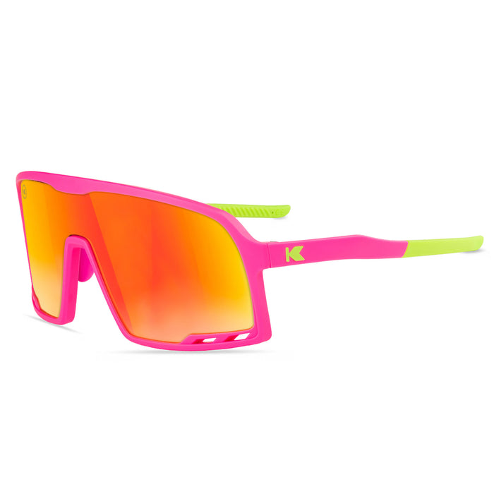 Sunglasses with pink frame and orange-red lenses on a white background. Now available from ICEGRIPPER, the Knockaround Campeone, in Spring Break combines advanced performance technology with rugged outdoor style — ideal for trail runners, winter hikers, mountain trekkers, and polar explorers who demand comfort and clarity in challenging light conditions.