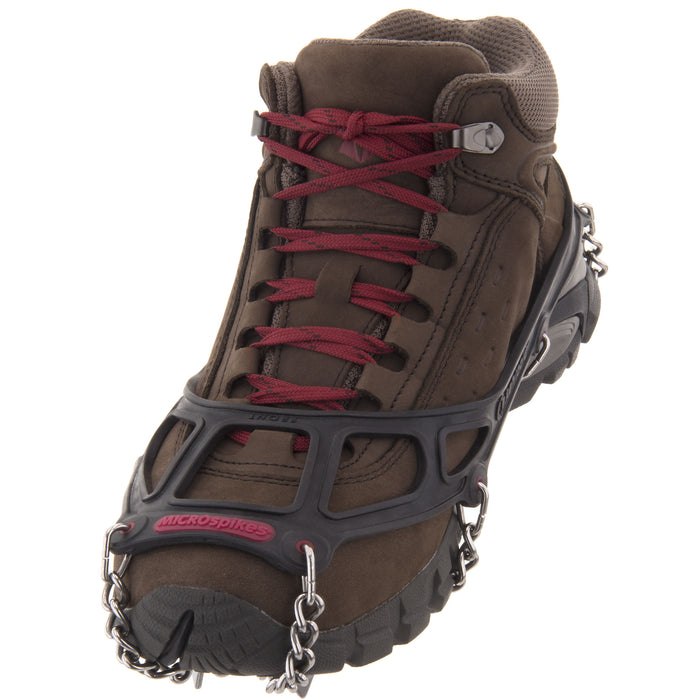 Black Kahtoola Microspikes on a boot, showing elastomer sling and toe bale, from ICEGRIPPER