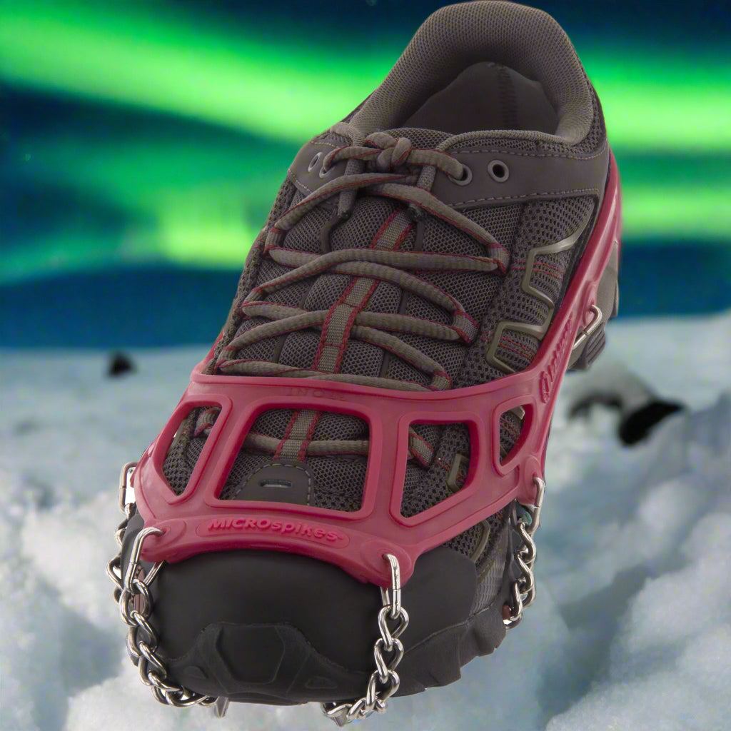 Red Kahtoola Microspikes on a trail shoe, showing elastomer sling and toe bale, from ICEGRIPPER